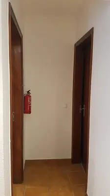 an empty hallway with two doors and a fire extinguisher at Atlantis Flat. Relaxing Moments in Machico