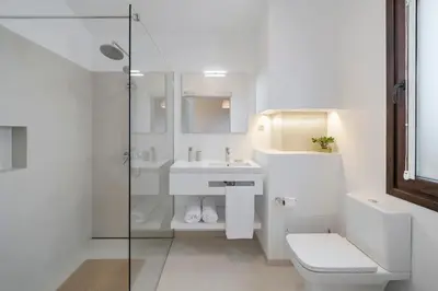 a white bathroom with a toilet and a sink at Southern Sunny House by An Island Apart in Calheta