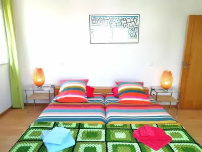 a bed with colorful blankets and pillows in a room at Casa Luminosa in Carrapateira