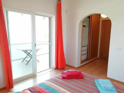 a bedroom with a bed and a large window at Casa Luminosa in Carrapateira
