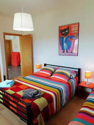 a bedroom with a bed with a colorful blanket at Casa Luminosa in Carrapateira