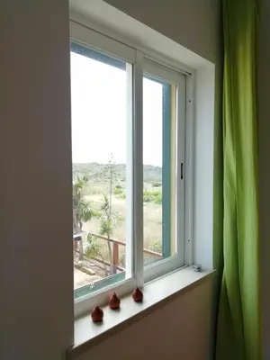 a window with vases sitting on a window sill at Casa Luminosa in Carrapateira