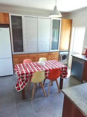 a kitchen with a table and chairs with a red and white checkered table at Casa Luminosa in Carrapateira