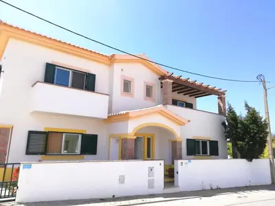 a white house with a fence in front of it at Casa Luminosa in Carrapateira