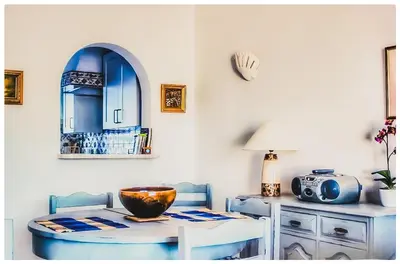a living room with a blue couch and a table at 38, Vila Gaivota in Luz