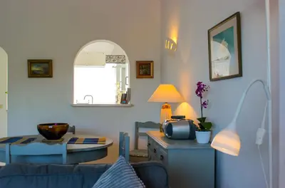 a room with a table and a balcony with palm trees at 38, Vila Gaivota in Luz