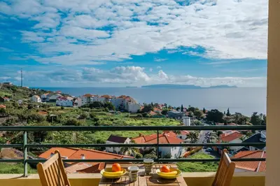 a table with chairs and a view of the ocean at Vista Mar - Modern Sea Views In Caniço de Baixo in Caniço