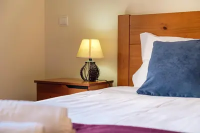 a bed with a blue pillow and a lamp on a table at Vista Mar - Modern Sea Views In Caniço de Baixo in Caniço
