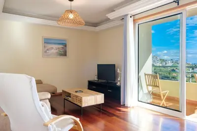 a living room with a couch and a tv at Vista Mar - Modern Sea Views In Caniço de Baixo in Caniço