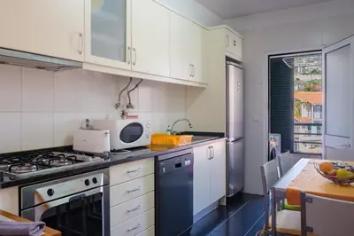 a kitchen with white cabinets and a stove top oven at Vista Mar - Modern Sea Views In Caniço de Baixo in Caniço
