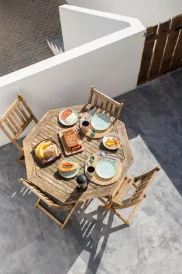 a wooden table with plates of food on it at Casa Bombordo in Carrapateira