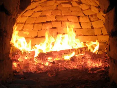 a brick oven with a fire in it at Russo Surf Resort - Vale Figueiras in Aljezur