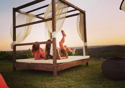 a group of girls laying on a bed in the grass at Russo Surf Resort - Vale Figueiras in Aljezur