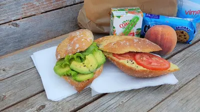 two sandwiches sitting on a table with a bag of food at Russo Surf Resort - Vale Figueiras in Aljezur