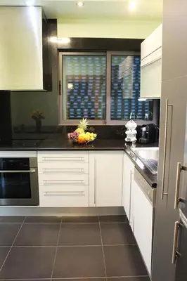 a kitchen with white cabinets and black counter tops at MCStylo-Residenza in Funchal