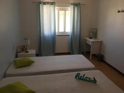 two beds in a small room with a window at Casa Maré in Sagres