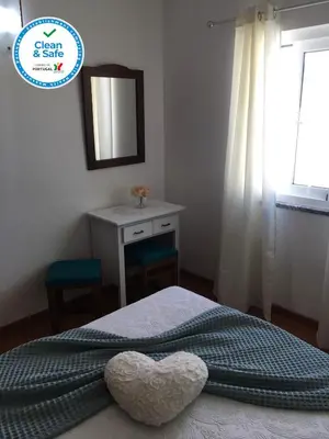 a bedroom with a heart pillow on a bed at Casa Maré in Sagres