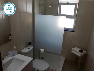 a bathroom with a toilet and a sink and a window at Casa Maré in Sagres