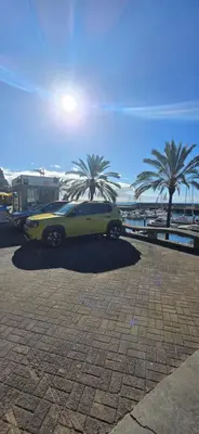 a yellow car parked in a parking lot with palm trees at Casa da Praia in Calheta
