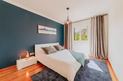 a bedroom with a large bed and a blue wall at Funchal Lounge Apartment II by Amazing Madeira in Funchal
