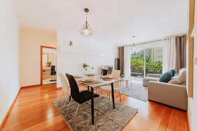 a dining room and living room with a table and chairs at Funchal Lounge Apartment II by Amazing Madeira in Funchal