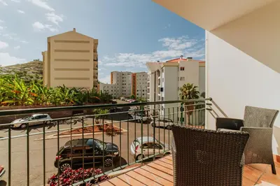 a balcony with chairs and a view of a city at Funchal Lounge Apartment II by Amazing Madeira in Funchal