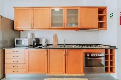 a kitchen with wooden cabinets and a sink and a microwave at Funchal Lounge Apartment II by Amazing Madeira in Funchal