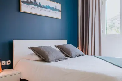 a bedroom with blue walls and a bed with two pillows at Funchal Lounge Apartment II by Amazing Madeira in Funchal