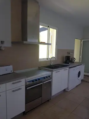 a kitchen with a stove and a sink and a dishwasher at Casinha Vista Mar in Porto Santo