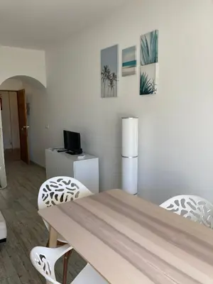 a dining room with a wooden table and two chairs at Magnolia Mar Apartamentos in Lagos
