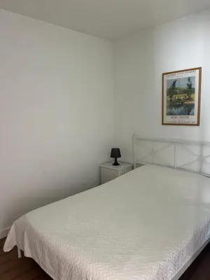 a white bed in a bedroom with a picture on the wall at Magnolia Mar Apartamentos in Lagos