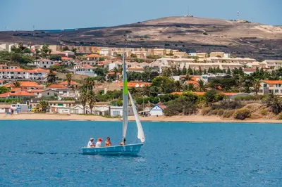 a group of three people on a sail boat in the water at Porto Santo Blue House in Porto Santo