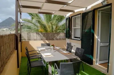 a table and chairs on the balcony of a house at Porto Santo Blue House in Porto Santo