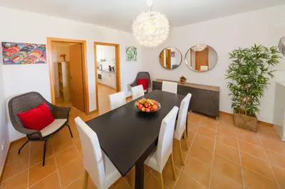 a dining room with a black table and white chairs at Porto Santo Blue House in Porto Santo