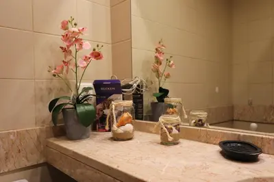a bathroom counter with flowers and other items on it at Funchal Apartment, with pool in Funchal