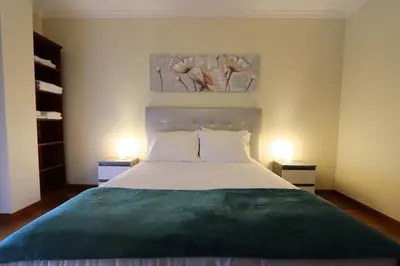 a bedroom with a large bed with two lamps at Funchal Apartment, with pool in Funchal