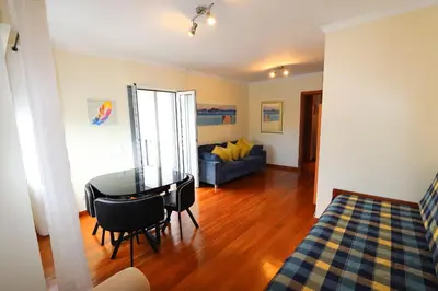 a living room with a table and a couch at Funchal Apartment, with pool in Funchal