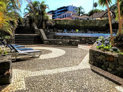 a patio with two lounge chairs and a swimming pool at Funchal Apartment, with pool in Funchal