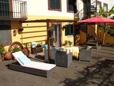 a patio with a table and chairs and an umbrella at Purple Studio in Funchal