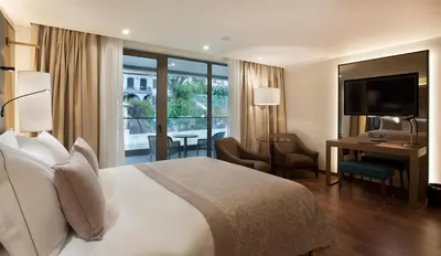 a hotel room with a bed and a desk and a television at TURIM Santa Maria Hotel in Funchal