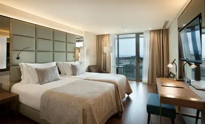 a hotel room with a large bed and a desk at TURIM Santa Maria Hotel in Funchal