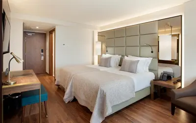 a hotel room with a large bed and a desk at TURIM Santa Maria Hotel in Funchal