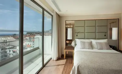 a bedroom with a bed and a large window at TURIM Santa Maria Hotel in Funchal