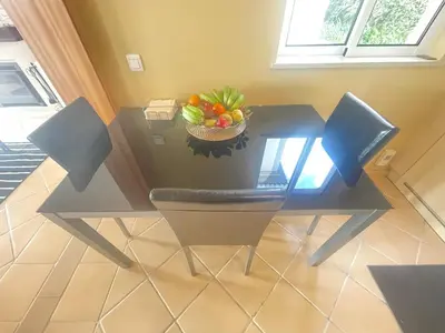 a dining room table with a bowl of fruit on it at Sea and Sun 4 You - Palheiro Village in Funchal