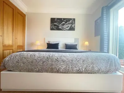 a large bed in a bedroom with two lamps at Sea and Sun 4 You - Palheiro Village in Funchal