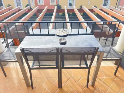 a table and chair on a balcony with a roof at Sea and Sun 4 You - Palheiro Village in Funchal