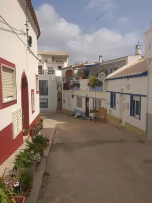 an alley in a town with white and blue buildings at Casa Rose in Almádena