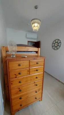 a wooden dresser with a lamp on top of it at Casa Rose in Almádena