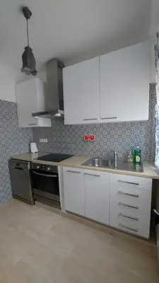a kitchen with white cabinets and a sink at Casa Rose in Almádena