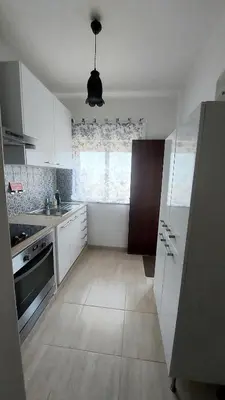 a kitchen with white cabinets and a large window at Casa Rose in Almádena